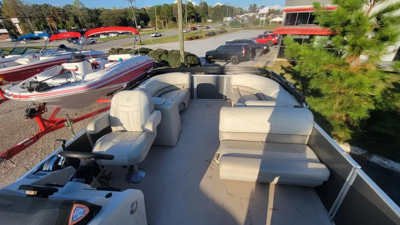 Slide: The Image of 2020 Cypress Cay Seabreeze 232 pontoon boat with spacious seating and helm, parked outdoors. - 7