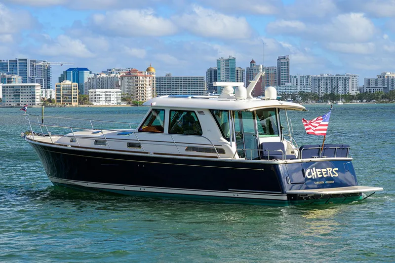 Slide: The Image of 2023 Sabre 48 Salon Express yacht cruising near city skyline. - 10