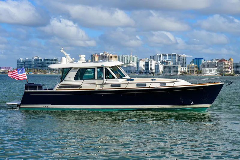 Slide: The Image of 2023 Sabre 48 Salon Express yacht cruising near city skyline. - 2