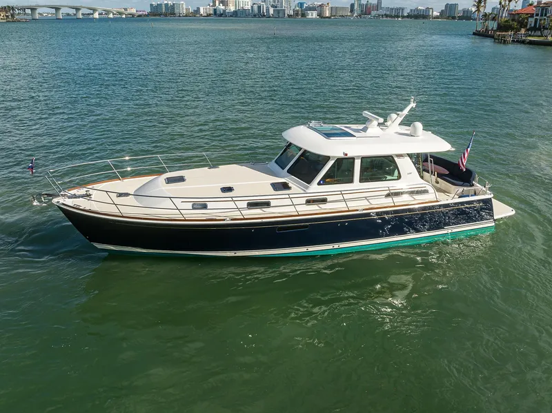 Slide: The Image of 2023 Sabre 48 Salon Express yacht cruising on a calm waterway. - 23