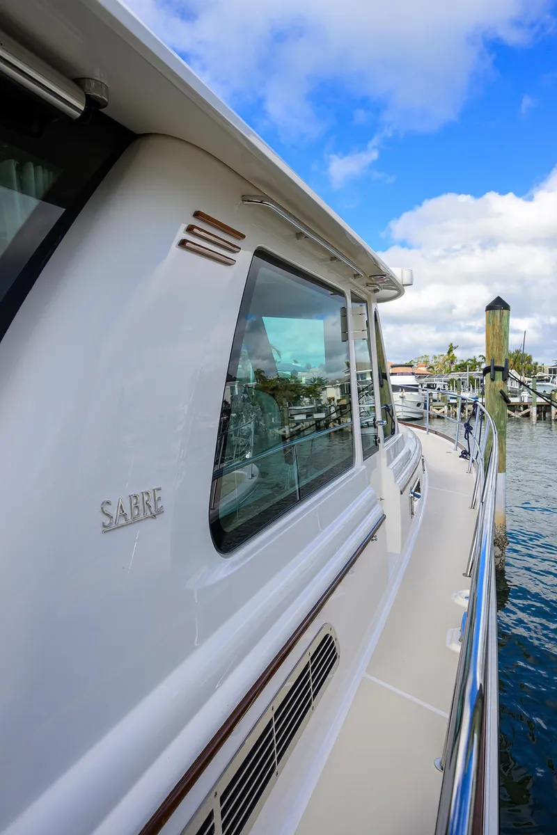 Slide: The Image of 2023 Sabre 48 Salon Express yacht docked at marina under blue sky. - 35
