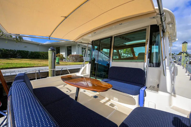 Slide: The Image of 2023 Sabre 48 Salon Express yacht with outdoor seating and table under canopy. - 47