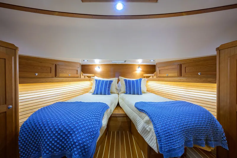 Slide: The Image of Interior of 2023 Sabre 48 Salon Express with twin beds and blue bedding. - 49