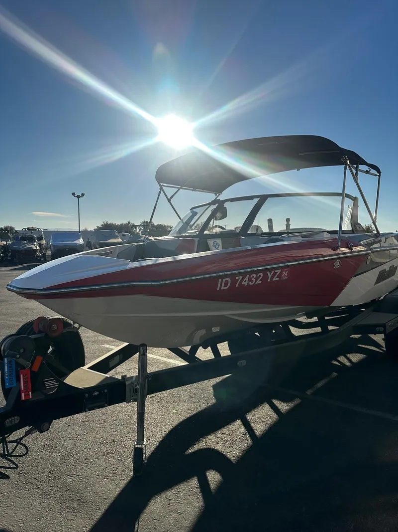 Slide: The Image of 2019 Malibu TXi Mo boat on trailer under bright sun. - 5