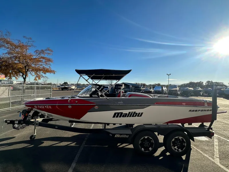 Slide: The Image of 2019 Malibu TXi Mo boat on trailer in sunny parking lot. - 6