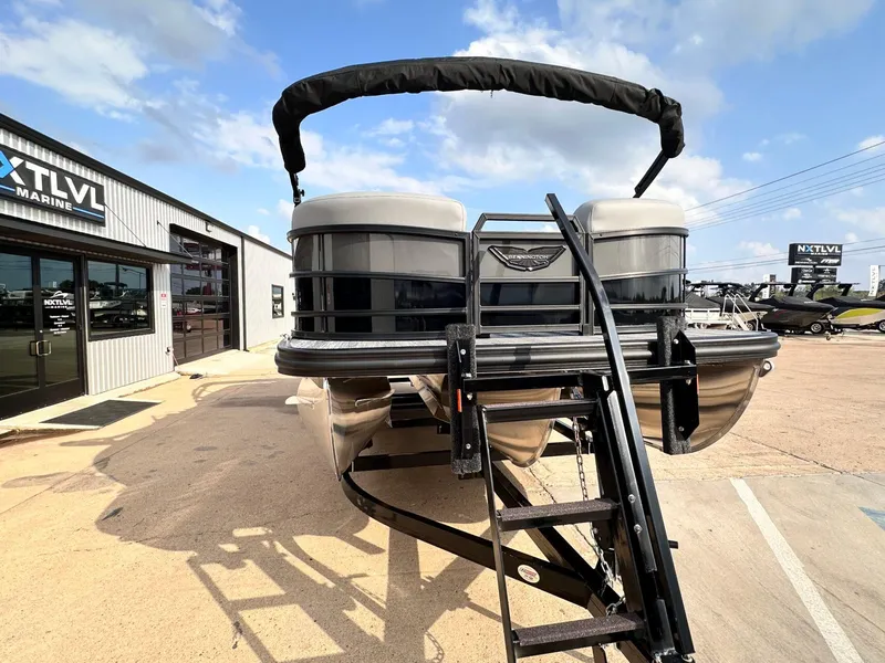 Slide: The Image of 2025 Bennington 22MFB pontoon boat at dealership, front view with ladder and canopy. - 11