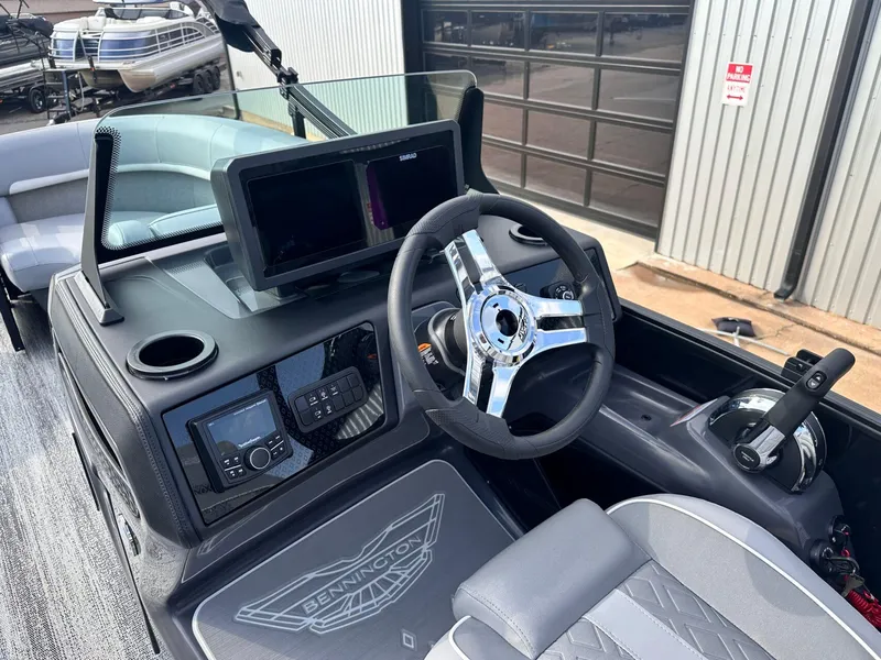 Slide: The Image of 2025 Bennington 22MFB boat dashboard with steering wheel, digital controls, and seating. - 22