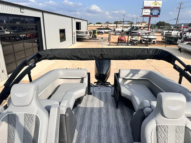 Slide: The Image of 2025 Bennington 22MFB pontoon boat with sleek gray seating and modern design at a dealership. - 28