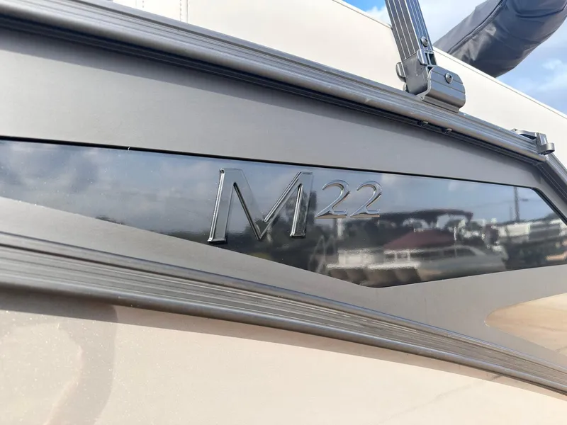 Slide: The Image of 2025 Bennington 22MFB boat with sleek design and M22 emblem. - 4
