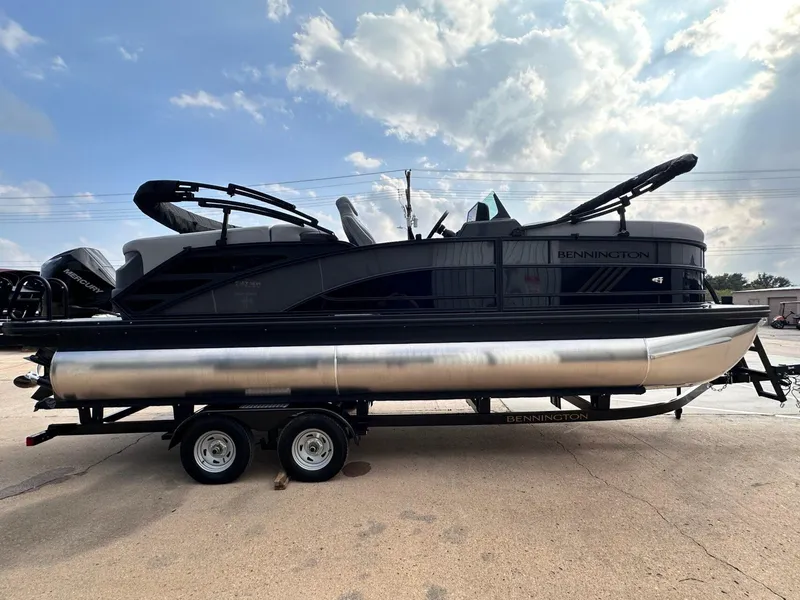Slide: The Image of 2025 Bennington 22MFB pontoon boat on trailer under a partly cloudy sky. - 9