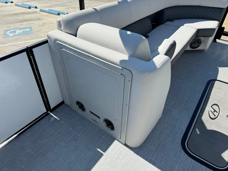 Slide: The Image of 2022 Harris Sunliner 250 boat interior with gray seating and speaker system. - 12