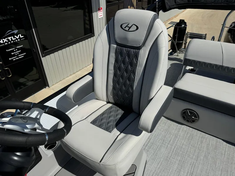 Slide: The Image of Captain's chair on 2022 Harris Sunliner 250 boat, featuring luxurious gray upholstery and diamond stitching. - 14