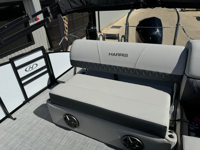 Slide: The Image of 2022 Harris Sunliner 250 boat interior with gray seating and speaker system. - 21