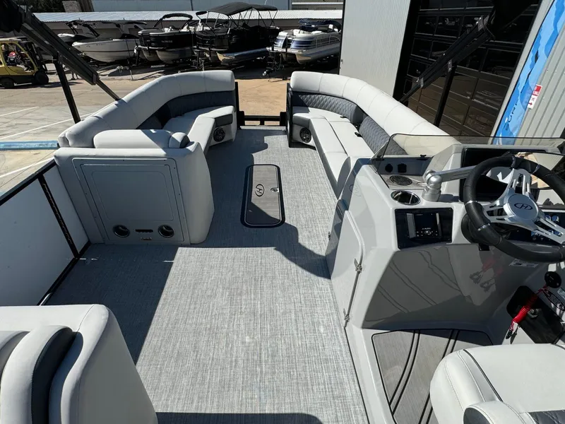 Slide: The Image of 2022 Harris Sunliner 250 pontoon boat interior with spacious seating and modern helm. - 30