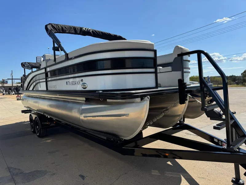 Slide: The Image of 2022 Harris Sunliner 250 pontoon boat on trailer under clear blue sky. - 5