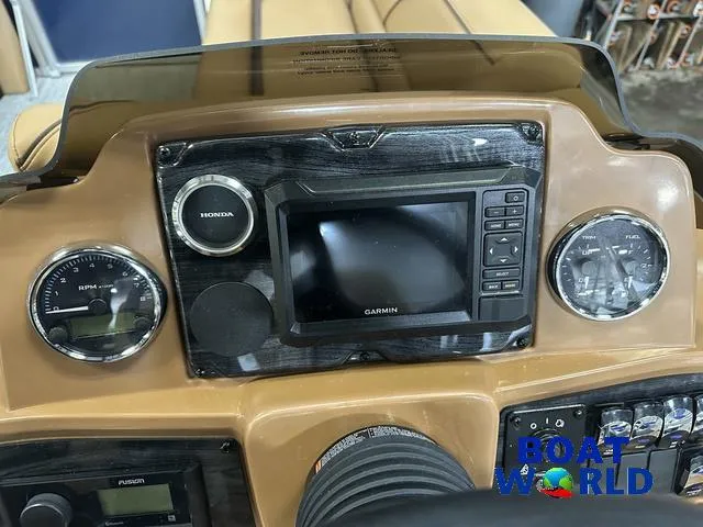 Slide: The Image of 2025 Tahoe Sport 23' Fish & Cruise dashboard with Garmin display and Honda controls. - 15