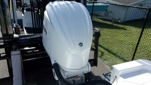 Slide: The Image of 2025 Sportsman Masters 247 boat engine, parked near a chain-link fence. - 13