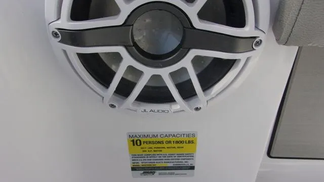 Slide: The Image of JL Audio speaker on 2025 Sportsman Masters 247 boat, capacity label for 10 people or 1800 lbs. - 18