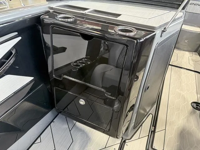 Slide: The Image of Interior of 2025 Yamaha Boats 222XE, featuring sleek black storage unit with cup holders. - 15