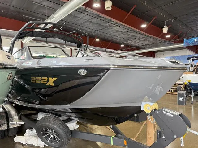 Slide: The Image of 2025 Yamaha Boats 222XE in showroom, sleek black and gray design. - 3