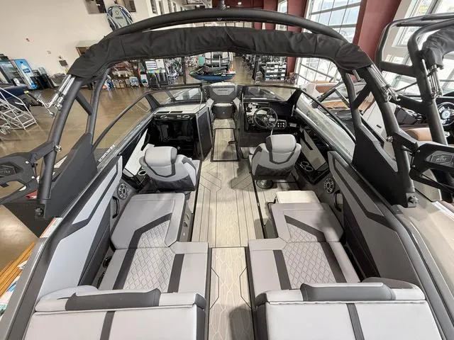 Slide: The Image of 2025 Yamaha Boats 222XE interior with modern seating and sleek design in showroom. - 6