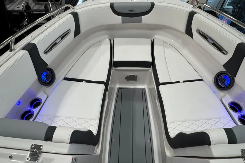 Slide: The Image of 2025 Chaparral 247 SSX boat interior with white seating, cup holders, and speakers. - 14