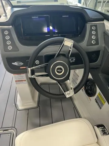 Slide: The Image of 2025 Chaparral 247 SSX boat interior with white seating, cup holders, and blue LED lighting. - 9