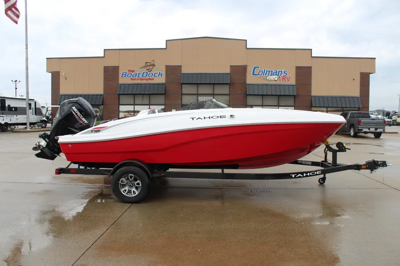 The Image of 2025 Tahoe T18 boat on trailer, red and white, parked outside dealership. - 0