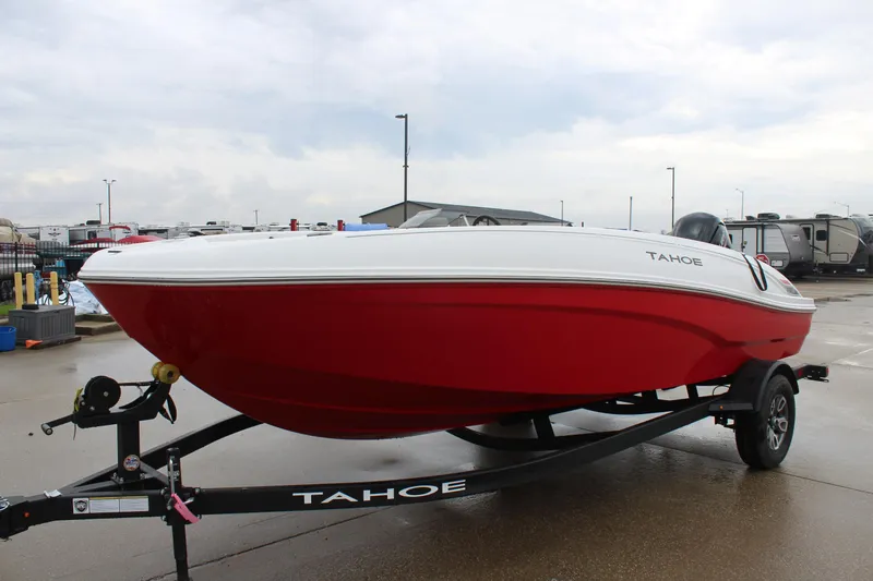 Slide: The Image of 2025 Tahoe T18 boat in red and white on a trailer at a marina. - 3
