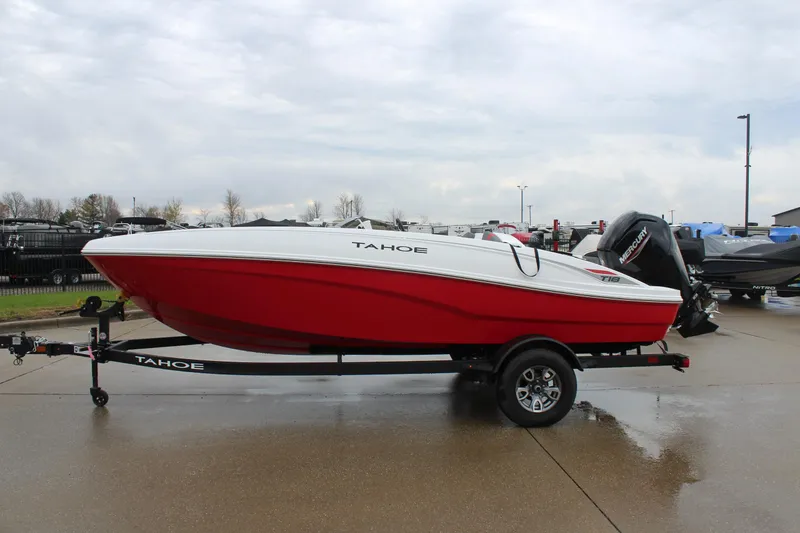 Slide: The Image of 2025 Tahoe T18 boat in red and white on a trailer, parked outdoors. - 4