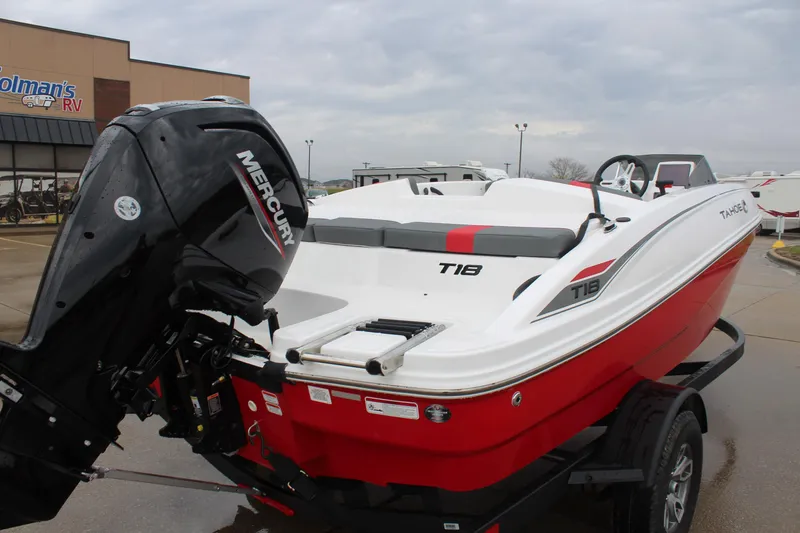 Slide: The Image of 2025 Tahoe T18 boat with Mercury engine, red and white design, parked outdoors. - 7