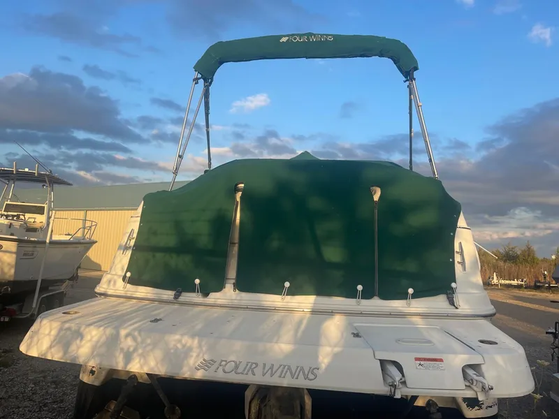 Slide: The Image of 2005 Four Winns 248 Vista boat with green canopy, parked outdoors. - 3