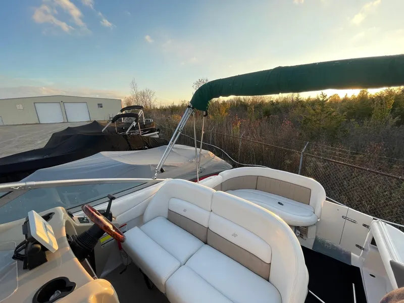 Slide: The Image of 2005 Four Winns 248 Vista boat with white seating and green canopy, parked outdoors. - 30