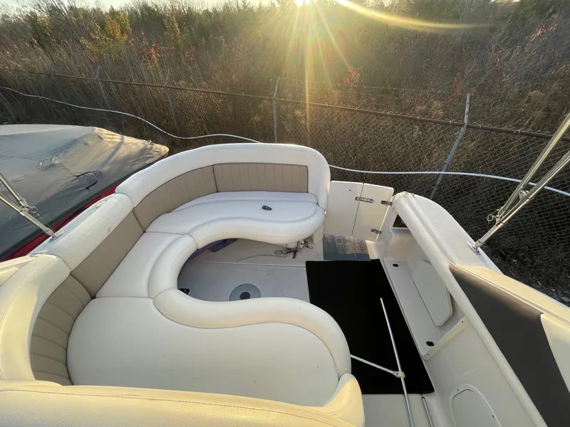 Slide: The Image of 2005 Four Winns 248 Vista boat interior with curved seating and sunlit background. - 6