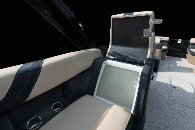 Slide: The Image of 2025 Berkshire 24RFXCTS275 boat interior with open storage compartment and beige seating. - 10