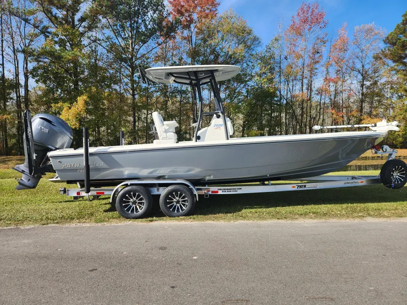 The Image of 2025 Pathfinder 2600 HPS boat on trailer, parked outdoors with autumn trees in background. - 0
