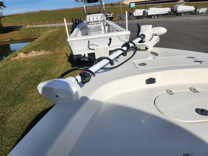 Slide: The Image of 2025 Pathfinder 2600 HPS boat with trolling motor, parked on grass near water. - 11