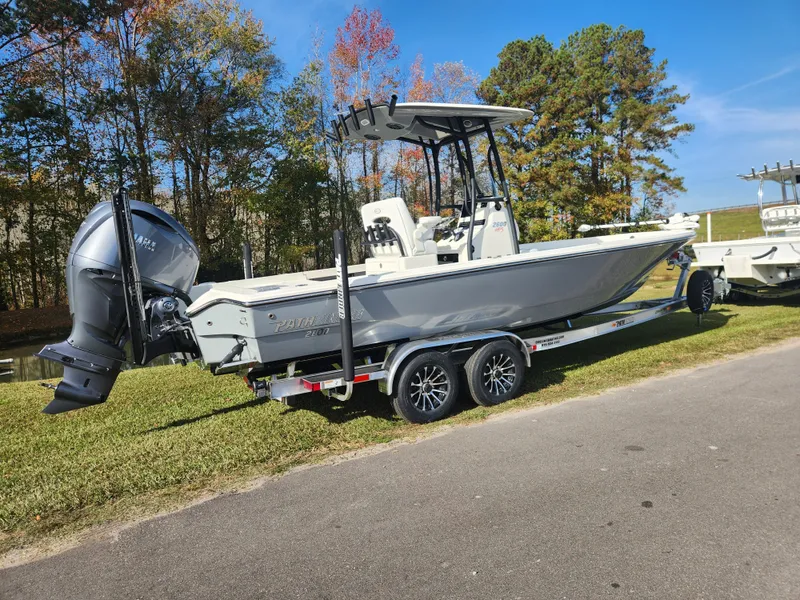 Slide: The Image of 2025 Pathfinder 2600 HPS boat on trailer, parked on grass, with trees in background. - 2