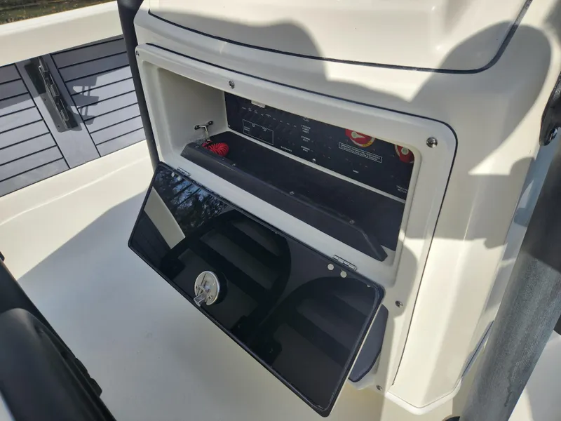 Slide: The Image of Pathfinder 2600 HPS 2025 boat console storage compartment with open hatch. - 21