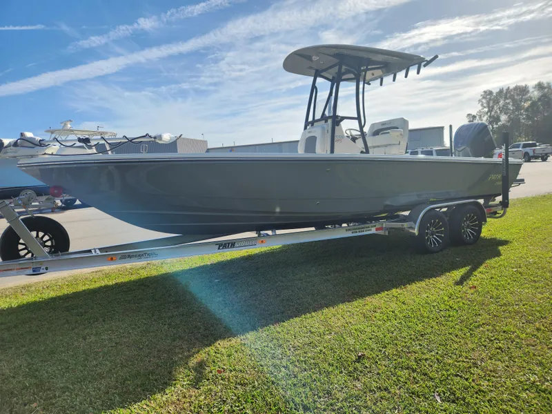 Slide: The Image of 2025 Pathfinder 2600 HPS boat on trailer, parked on grass under a clear sky. - 7