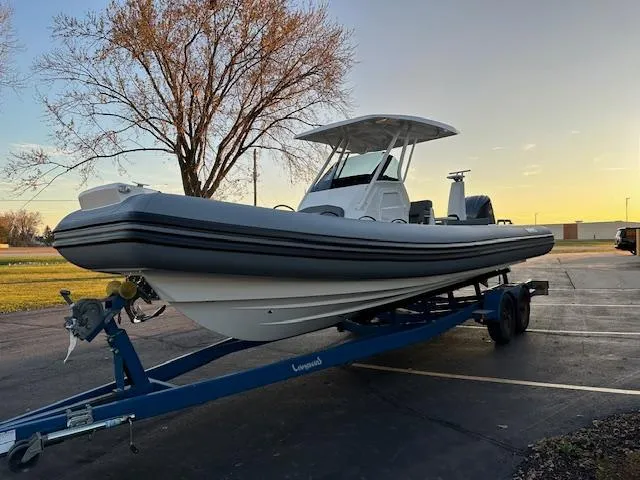 Slide: The Image of 2025 Brig Eagle 8 boat on trailer at sunset, parked in a lot. - 11