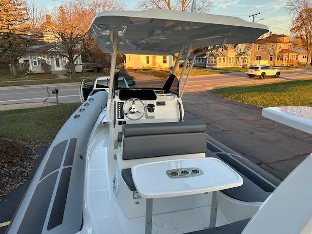 Slide: The Image of 2025 Brig Eagle 8 boat with seating and table, parked in a residential area. - 13