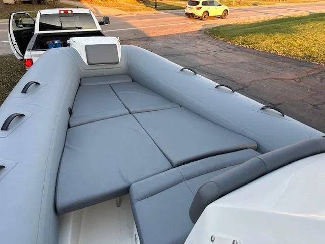 Slide: The Image of 2025 Brig Eagle 8 boat interior with gray seating, parked near a road. - 24