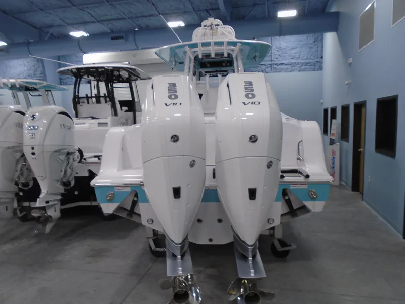 Slide: The Image of 2024 Sportsman Open 302 Center Console with twin outboard engines in showroom. - 2