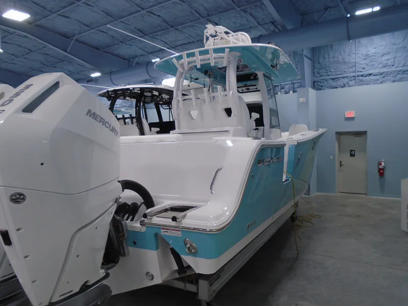 Slide: The Image of 2024 Sportsman Open 302 Center Console boat in showroom, featuring dual Mercury engines. - 3