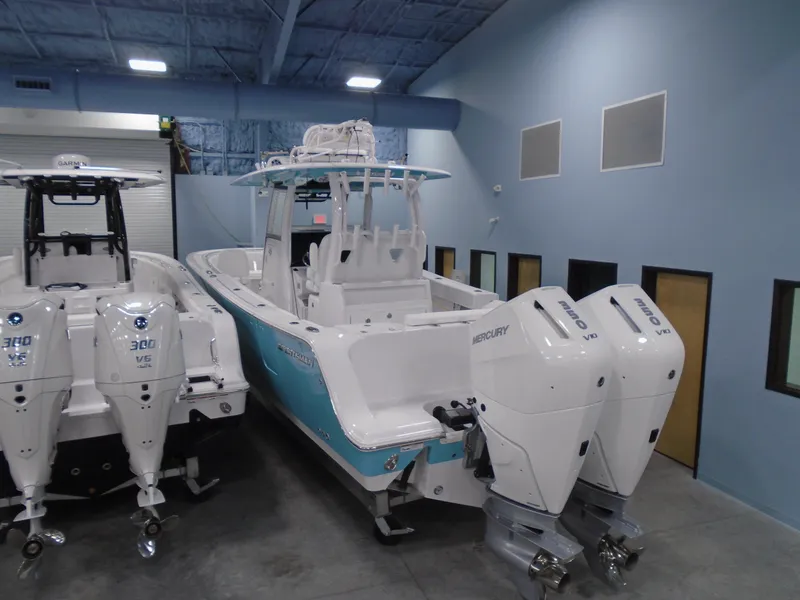 Slide: The Image of 2024 Sportsman Open 302 Center Console boat with twin Mercury engines in showroom. - 6