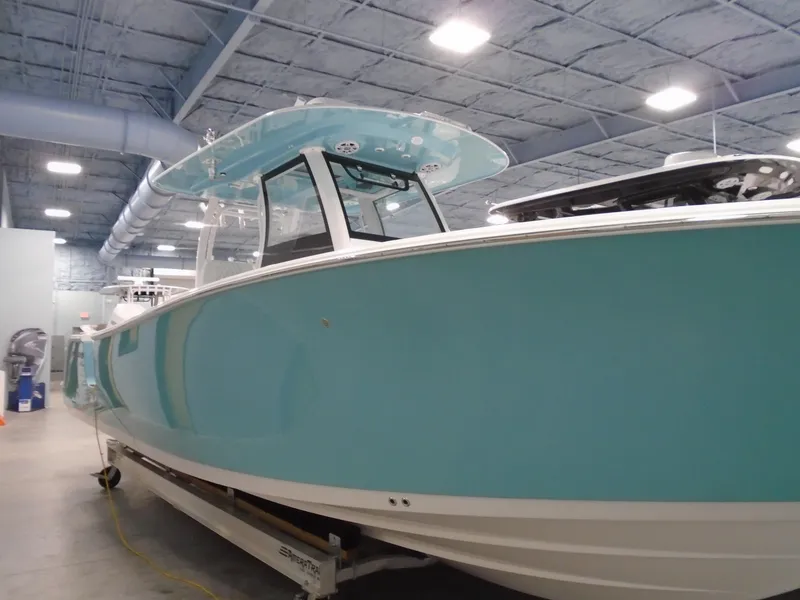 Slide: The Image of 2024 Sportsman Open 302 Center Console boat in a showroom, featuring a sleek blue design. - 7