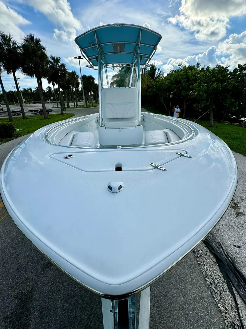 Slide: The Image of 2023 Contender Center Console boat with sleek design, parked outdoors under a blue sky. - 3