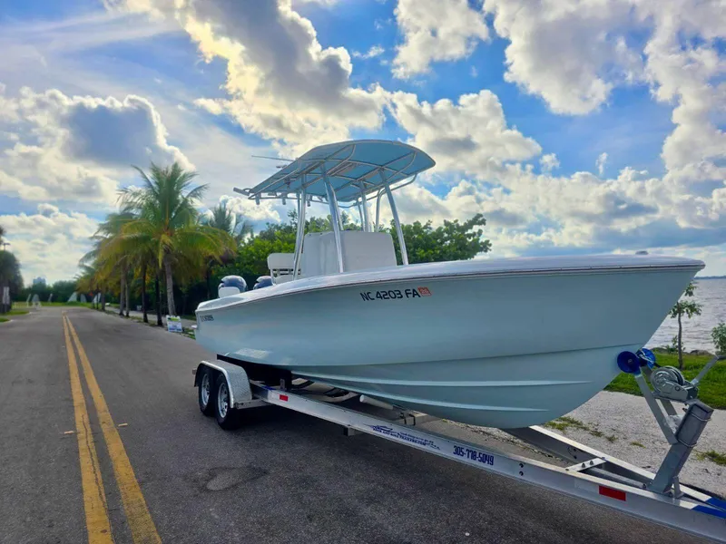 Slide: The Image of 2023 Contender Center Console boat on trailer by palm-lined road. - 4