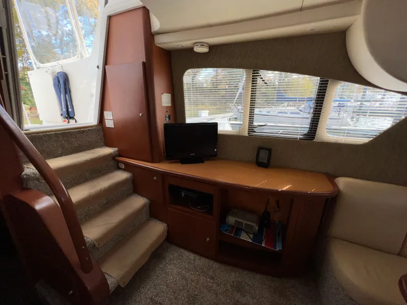 Slide: The Image of Interior of 2004 Silverton 39 Motor Yacht with stairs, TV, and windows. - 19